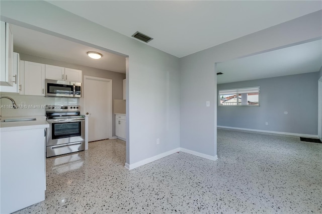 3731 SW 88th Pl, Miami, FL 33165 - kitchen featuring appliances with stainless steel finishes, white cabinets, light countertops, and dark speckled floor