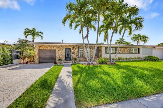 5025 SW 90th Ct, Miami, FL 33165 - view of front of house with decorative driveway, a garage, stone siding, and a front lawn