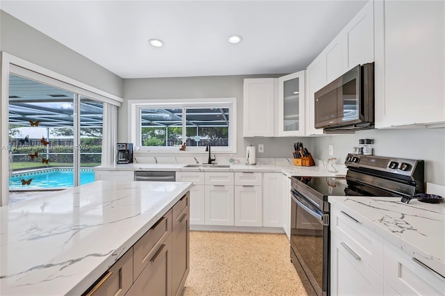 6736 Orchid Dr, Miami Lakes, FL 33014 - kitchen with stainless steel appliances, light stone counters, glass insert cabinets, recessed lighting, and white cabinets