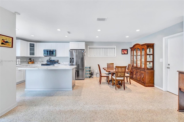 6736 Orchid Dr, Miami Lakes, FL 33014 - kitchen with stainless steel appliances, white cabinets, dark speckled floor, glass insert cabinets, and recessed lighting