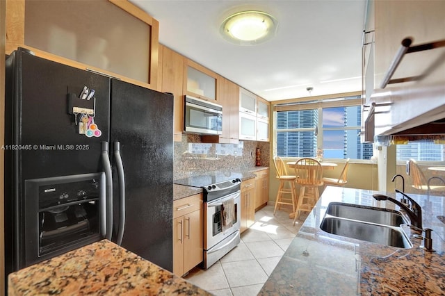 1833 S Ocean Dr Unit 1402, Hallandale Beach, FL 33009 - kitchen with appliances with stainless steel finishes, light tile patterned floors, decorative backsplash, glass insert cabinets, and light stone counters