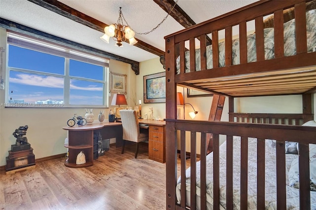 1833 S Ocean Dr Unit 1402, Hallandale Beach, FL 33009 - bedroom with beamed ceiling, a chandelier, built in desk, wood finished floors, and a textured ceiling