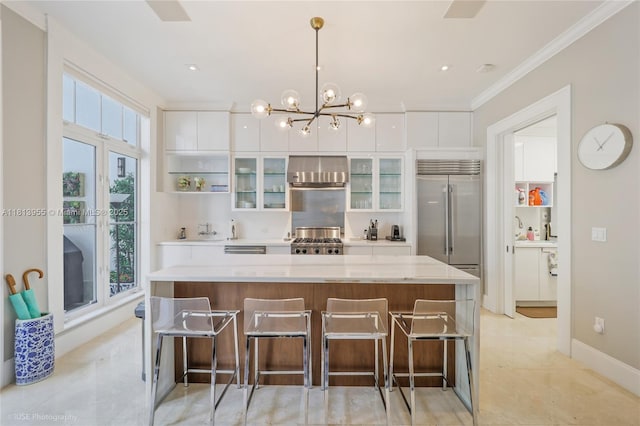 647 Almeria Ave, Coral Gables, FL 33134 - kitchen featuring built in refrigerator, a large island, stove, white cabinetry, and ornamental molding