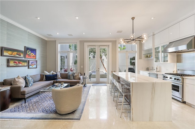 647 Almeria Ave, Coral Gables, FL 33134 - kitchen featuring stainless steel appliances, range hood, a kitchen bar, white cabinets, and french doors