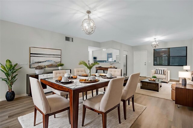 511 Ives Dairy Rd Unit 104-6, Miami, FL 33179 - dining area featuring a chandelier and light wood finished floors