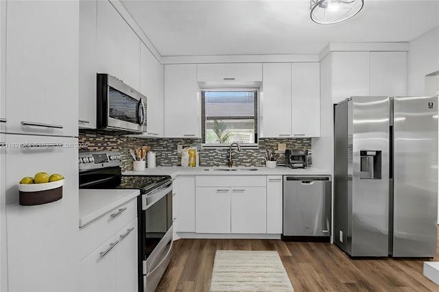 511 Ives Dairy Rd Unit 104-6, Miami, FL 33179 - kitchen featuring stainless steel appliances, light countertops, backsplash, and white cabinetry