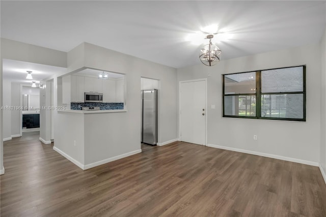 511 Ives Dairy Rd Unit 104-6, Miami, FL 33179 - kitchen featuring appliances with stainless steel finishes, white cabinetry, wood finished floors, and a chandelier