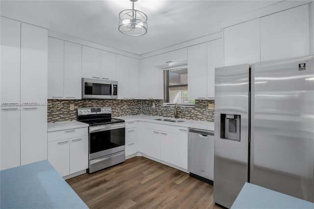 511 Ives Dairy Rd Unit 104-6, Miami, FL 33179 - kitchen with appliances with stainless steel finishes, light countertops, dark wood-style floors, and backsplash