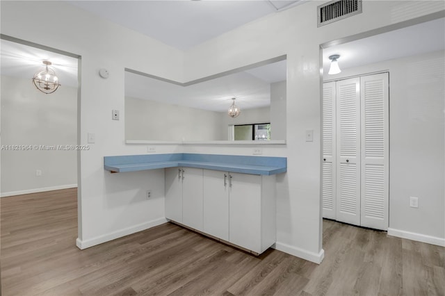 511 Ives Dairy Rd Unit 104-6, Miami, FL 33179 - kitchen featuring a chandelier, wood finished floors, and white cabinetry