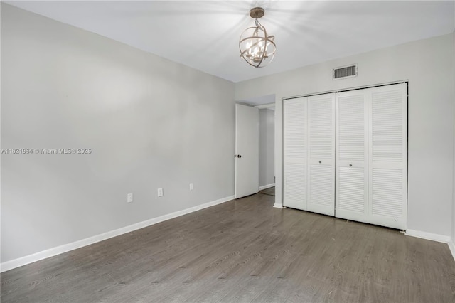 511 Ives Dairy Rd Unit 104-6, Miami, FL 33179 - unfurnished bedroom with wood finished floors, a chandelier, and a closet