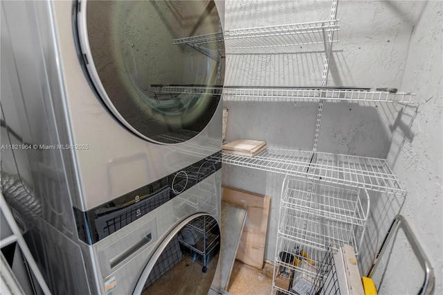 511 Ives Dairy Rd Unit 104-6, Miami, FL 33179 - laundry room featuring stacked washer / drying machine and a textured wall