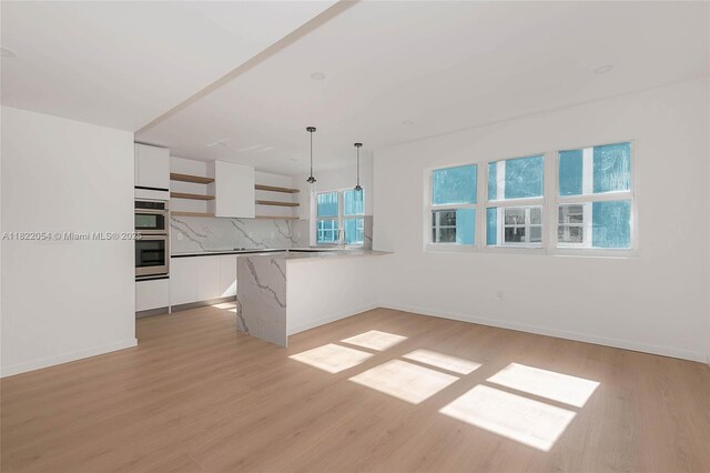824 SE 12th Ct, Fort Lauderdale, FL 33316 - kitchen featuring open shelves, white cabinetry, light wood-style floors, and decorative light fixtures
