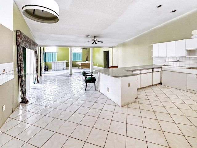 4550 NW 65th Way, Lauderhill, FL 33319 - kitchen featuring a ceiling fan, a textured ceiling, light tile patterned floors, a peninsula, and white cabinetry