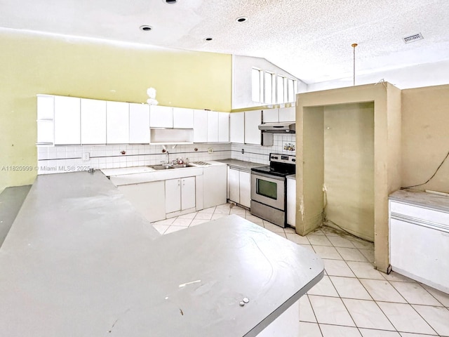 4550 NW 65th Way, Lauderhill, FL 33319 - kitchen with stainless steel range with electric stovetop, under cabinet range hood, vaulted ceiling, backsplash, and light tile patterned flooring