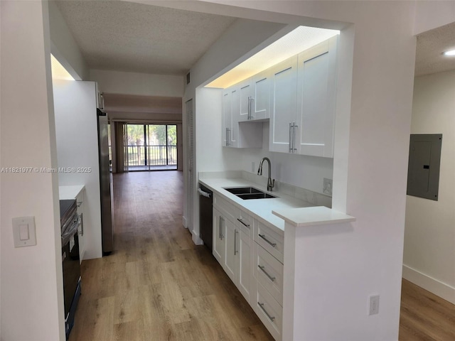 12755 SW 16th Ct Unit 201B, Pembroke Pines, FL 33027 - kitchen with electric panel, light wood-type flooring, appliances with stainless steel finishes, light countertops, and white cabinetry