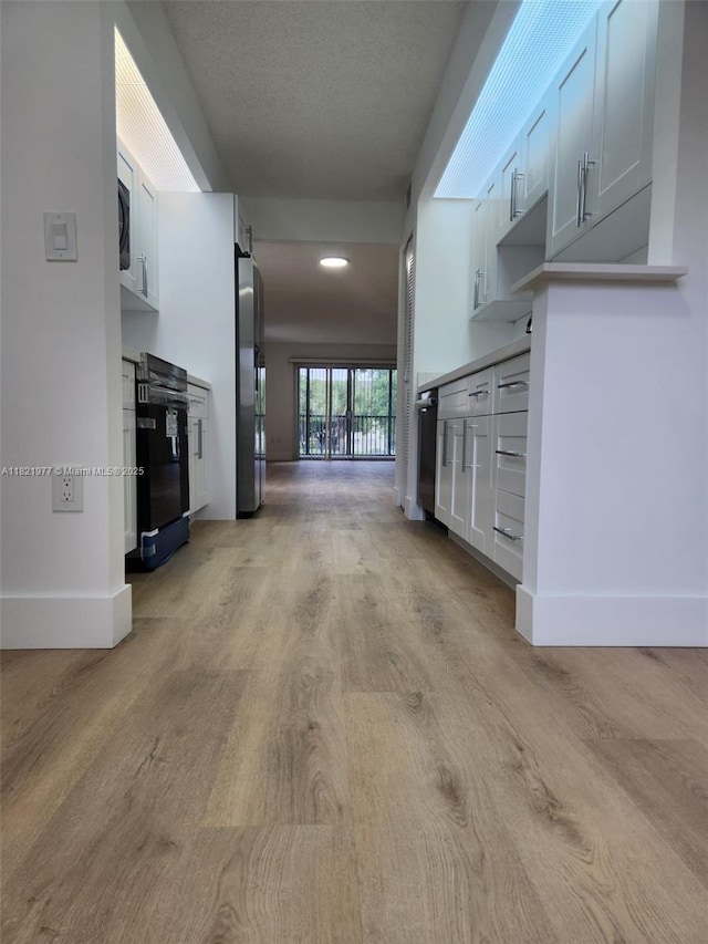 12755 SW 16th Ct Unit 201B, Pembroke Pines, FL 33027 - unfurnished living room featuring light wood-type flooring and a textured ceiling