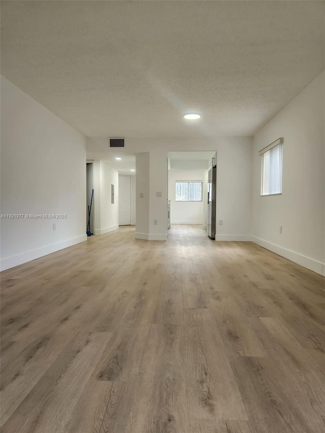 12755 SW 16th Ct Unit 201B, Pembroke Pines, FL 33027 - unfurnished living room with a textured ceiling, light wood finished floors, and recessed lighting