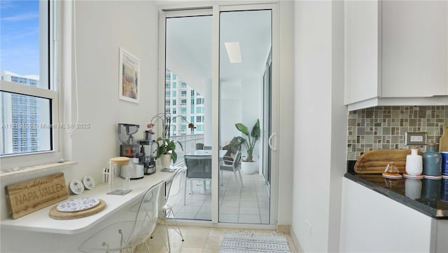 801 Brickell Key Blvd Unit 2210, Miami, FL 33131 - kitchen featuring healthy amount of natural light, decorative backsplash, white cabinets, and light tile patterned floors