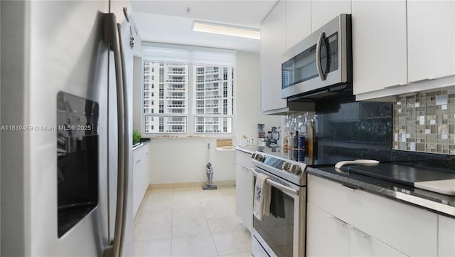 801 Brickell Key Blvd Unit 2210, Miami, FL 33131 - kitchen with stainless steel appliances, backsplash, white cabinetry, and dark countertops