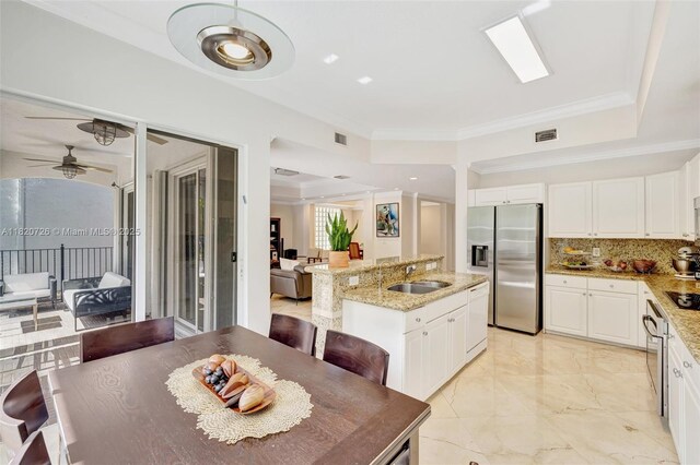 21235 NE 33rd Ave, Aventura, FL 33180 - kitchen with stainless steel fridge with ice dispenser, a center island with sink, a ceiling fan, backsplash, and light stone countertops