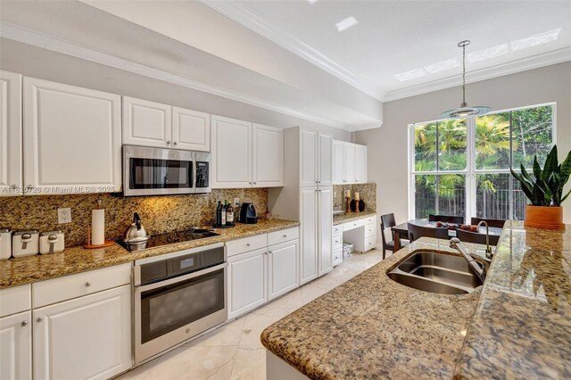21235 NE 33rd Ave, Aventura, FL 33180 - kitchen featuring stainless steel appliances, decorative backsplash, ornamental molding, white cabinetry, and light stone counters