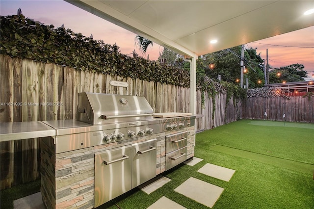2305 SW 19th Ter, Miami, FL 33145 - patio terrace at dusk with a fenced backyard and an outdoor kitchen