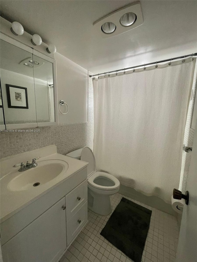 415 NE 2nd St Unit 223, Hallandale Beach, FL 33009 - bathroom featuring vanity, tile patterned floors, shower / bath combo with shower curtain, and tile walls