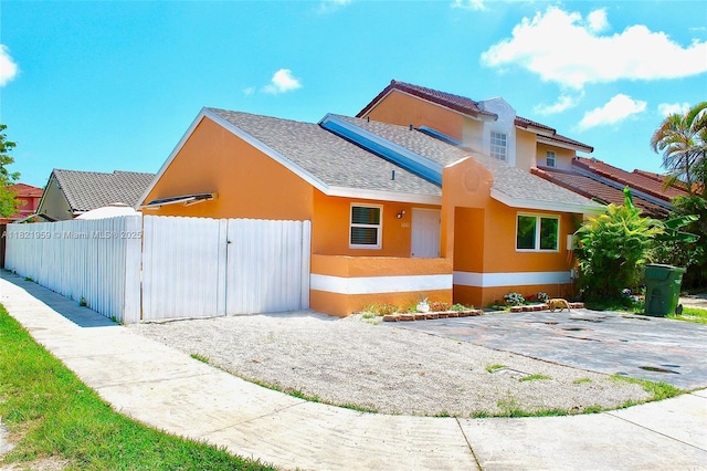 1061 SE 13th Ave Unit 1061, Homestead, FL 33035 - view of front of home with stucco siding, a gate, and a shingled roof