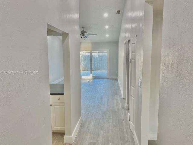 1061 SE 13th Ave Unit 1061, Homestead, FL 33035 - hallway featuring a textured wall and light wood-style floors
