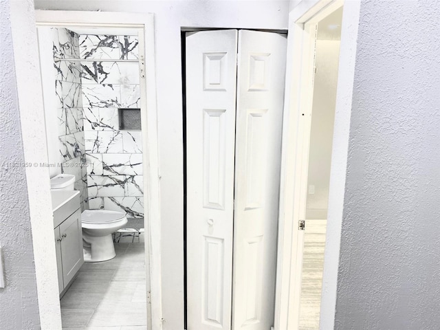 1061 SE 13th Ave Unit 1061, Homestead, FL 33035 - bathroom featuring a textured wall, vanity, a closet, and wood finished floors