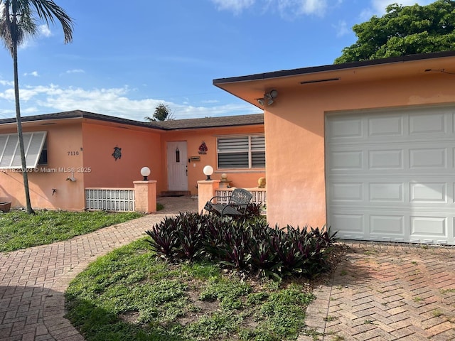 7110 SW 11th St, Pembroke Pines, FL 33023 - view of front of house featuring stucco siding, a garage, and decorative driveway