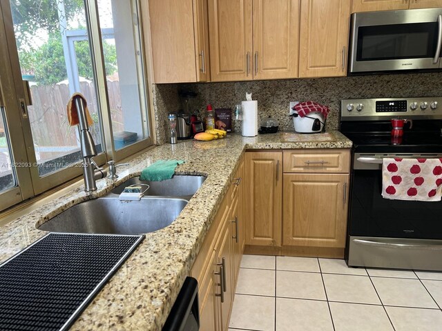 7110 SW 11th St, Pembroke Pines, FL 33023 - kitchen with stainless steel appliances, plenty of natural light, light tile patterned flooring, and tasteful backsplash