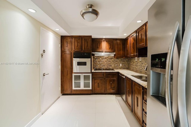 11 Island Ave Unit 1410, Miami Beach, FL 33139 - kitchen with appliances with stainless steel finishes, recessed lighting, decorative backsplash, under cabinet range hood, and dark brown cabinets