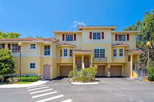 8940 NE 8th Ave Unit 1203, Miami, FL 33138 - view of front of property featuring stucco siding, a tile roof, a garage, and driveway