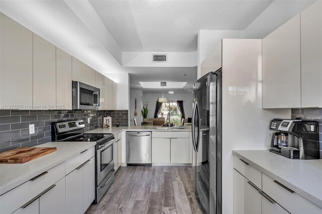 8940 NE 8th Ave Unit 1203, Miami, FL 33138 - kitchen with appliances with stainless steel finishes, light wood-style flooring, tasteful backsplash, and light countertops