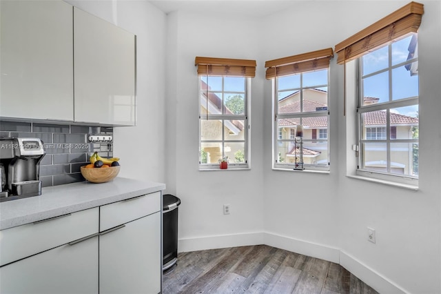 8940 NE 8th Ave Unit 1203, Miami, FL 33138 - kitchen featuring wood finished floors, backsplash, light countertops, and white cabinets