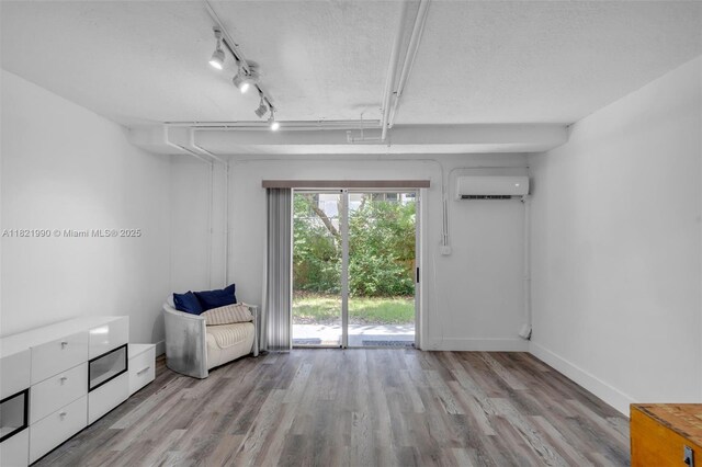8940 NE 8th Ave Unit 1203, Miami, FL 33138 - unfurnished room featuring a wall mounted air conditioner, wood finished floors, a textured ceiling, and rail lighting