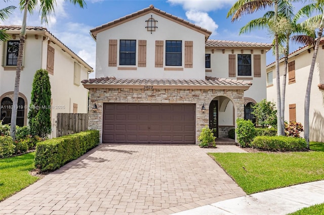 3809 Aspen Leaf Dr, Boynton Beach, FL 33436 - mediterranean / spanish-style house featuring a tile roof, stone siding, stucco siding, a garage, and decorative driveway