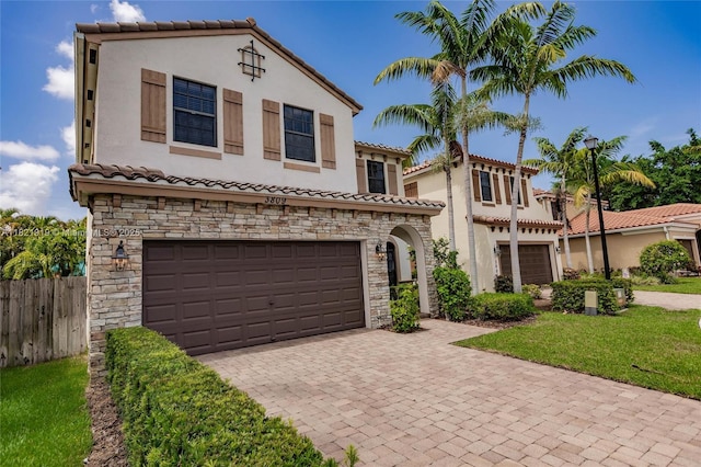 3809 Aspen Leaf Dr, Boynton Beach, FL 33436 - mediterranean / spanish house featuring stone siding, an attached garage, and a tiled roof