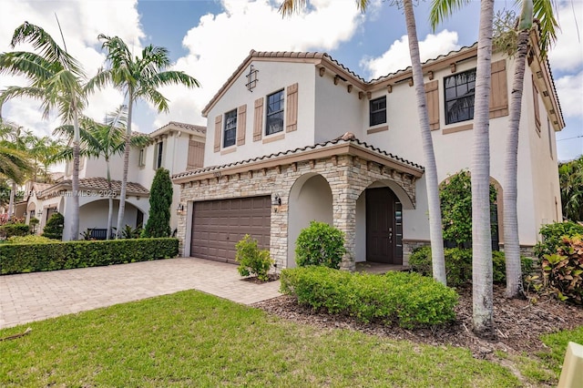 3809 Aspen Leaf Dr, Boynton Beach, FL 33436 - mediterranean / spanish-style house with stone siding, a garage, a tiled roof, stucco siding, and driveway
