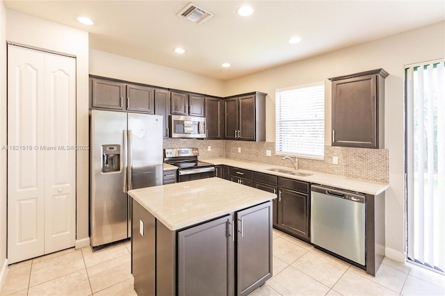 3809 Aspen Leaf Dr, Boynton Beach, FL 33436 - kitchen featuring stainless steel appliances, dark brown cabinets, decorative backsplash, a center island, and recessed lighting