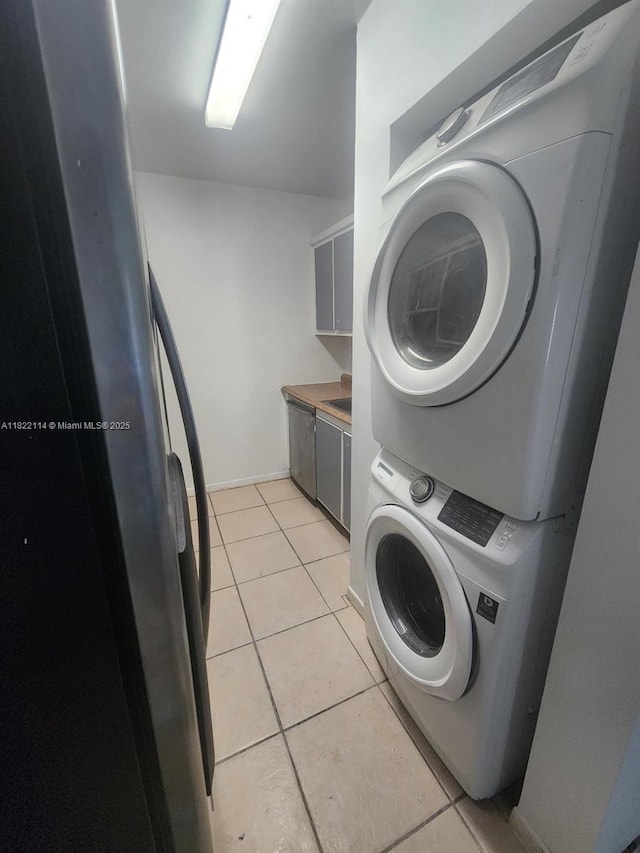 4150 NW 90th Ave Unit 203, Coral Springs, FL 33065 - laundry room featuring stacked washer / dryer and light tile patterned floors