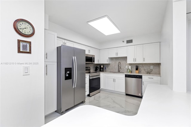 3530 Mystic Pointe Dr Unit 2108, Aventura, FL 33180 - kitchen with stainless steel appliances, tasteful backsplash, white cabinetry, light countertops, and light marble finish flooring