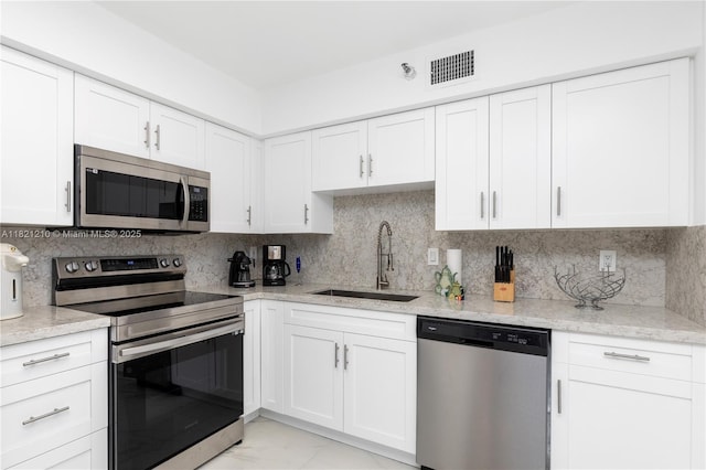 3530 Mystic Pointe Dr Unit 2108, Aventura, FL 33180 - kitchen featuring stainless steel appliances, light marble finish flooring, white cabinets, and tasteful backsplash