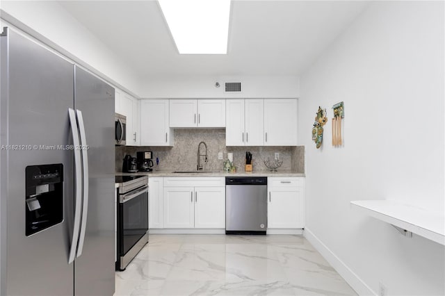 3530 Mystic Pointe Dr Unit 2108, Aventura, FL 33180 - kitchen featuring appliances with stainless steel finishes, light marble finish flooring, decorative backsplash, and white cabinetry