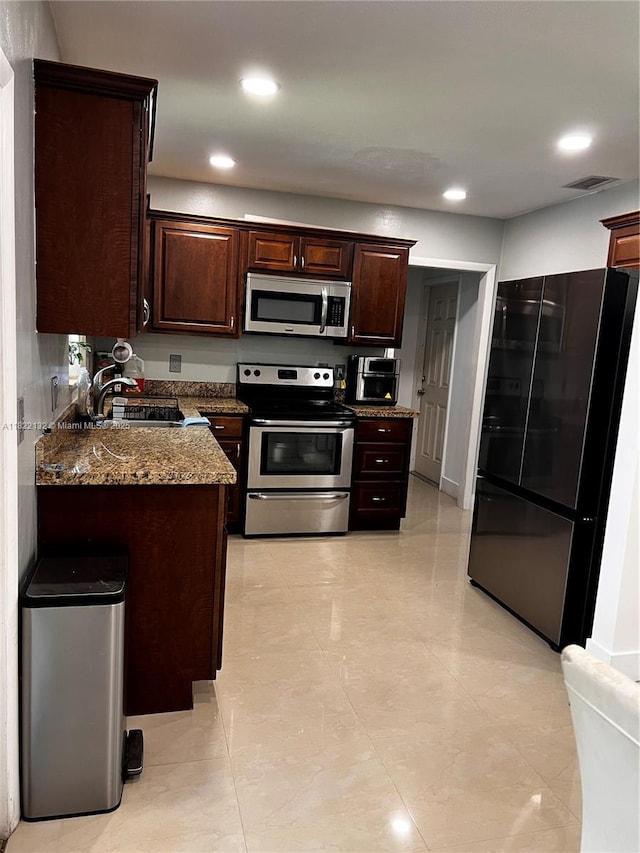 7151 Pershing St, Hollywood, FL 33024 - kitchen featuring appliances with stainless steel finishes, dark brown cabinets, recessed lighting, dark stone counters, and light tile patterned floors