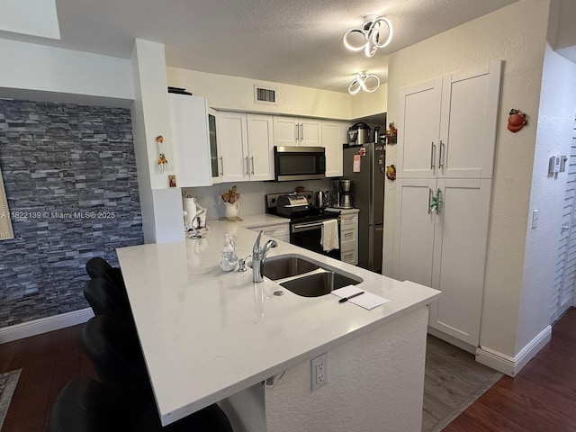 15400 SW 284th St Unit 1308, Homestead, FL 33033 - kitchen featuring stainless steel microwave, electric range oven, a peninsula, dark wood-style floors, and a textured ceiling