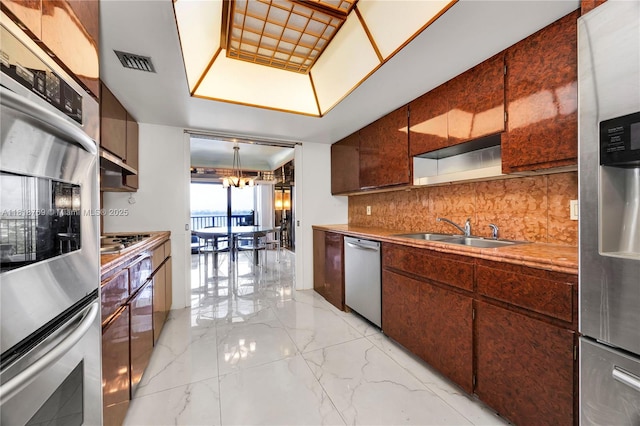 1800 NE 114th St Unit 1103, Miami, FL 33181 - kitchen featuring stainless steel appliances, tasteful backsplash, light marble finish flooring, a chandelier, and open shelves