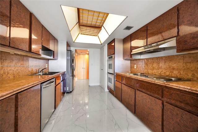 1800 NE 114th St Unit 1103, Miami, FL 33181 - kitchen with stainless steel appliances, under cabinet range hood, light marble finish flooring, and tasteful backsplash