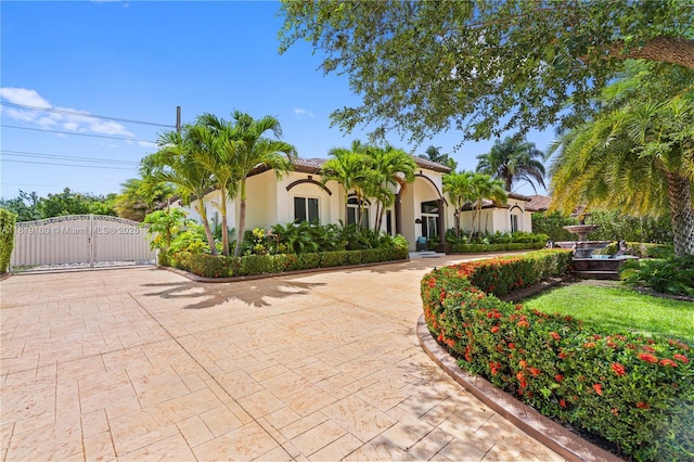 16601 SW 87th Ct, Palmetto Bay, FL 33157 - mediterranean / spanish-style home with a gate, stucco siding, and curved driveway